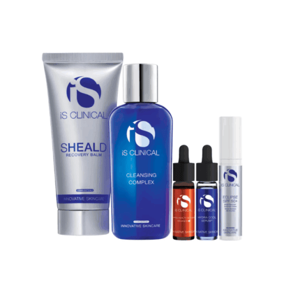 Five iS Clinical skincare products are arranged in a row: a tube labeled "Sheald Recovery Balm," a blue bottle labeled "Cleansing Complex," two small dropper bottles, and a small cylindrical tube labeled "Eclipse SPF 50+.